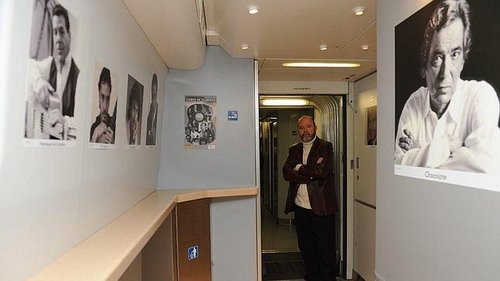 Paco Sánchez expone en el Ave. El fotógrafo Paco Sánchez, en el AVE junto a varios retratos, como el de El Chocolate, de su exposición.